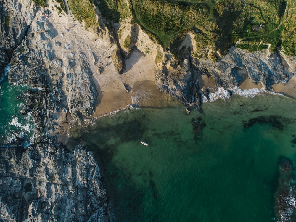 an aerial view of a rocky coastline with a body of water
