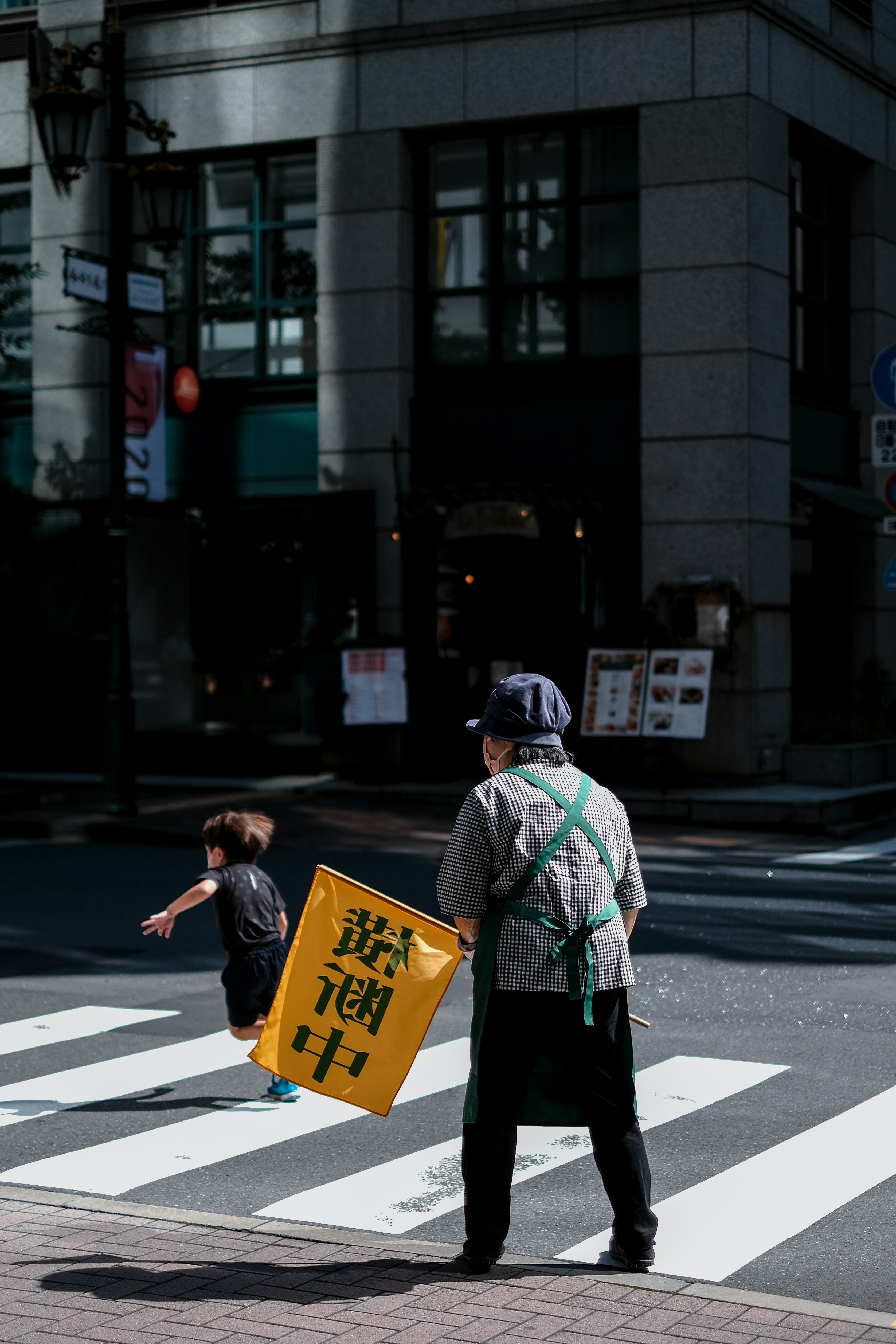 man in green and white jacket holding blue board