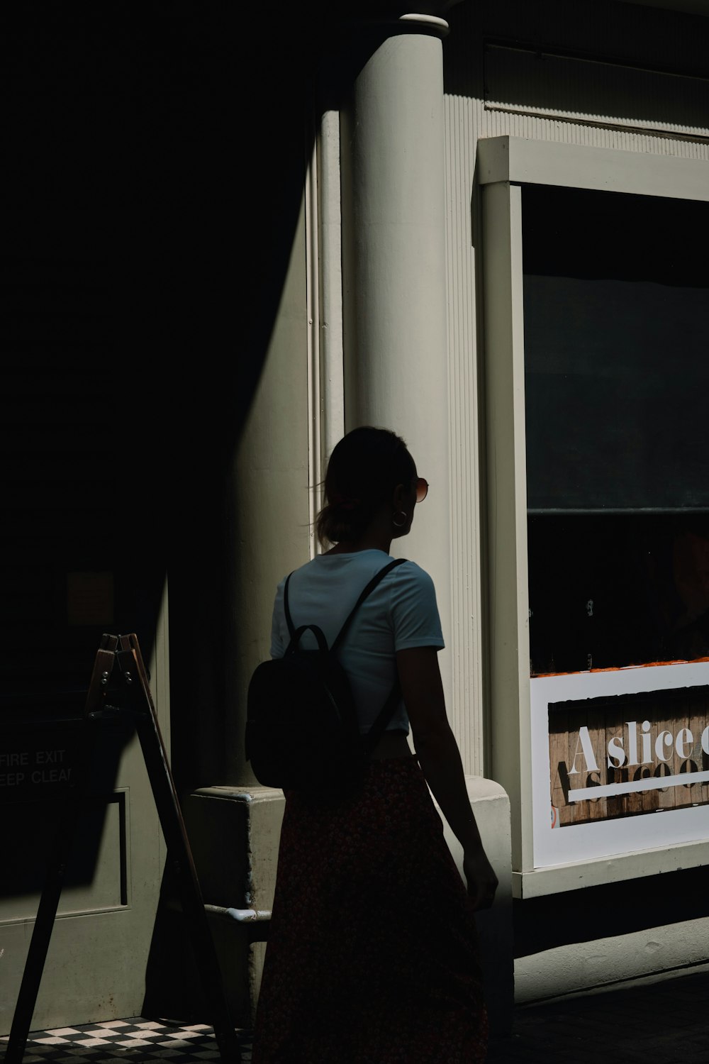 a woman standing in front of a window with a sign on it