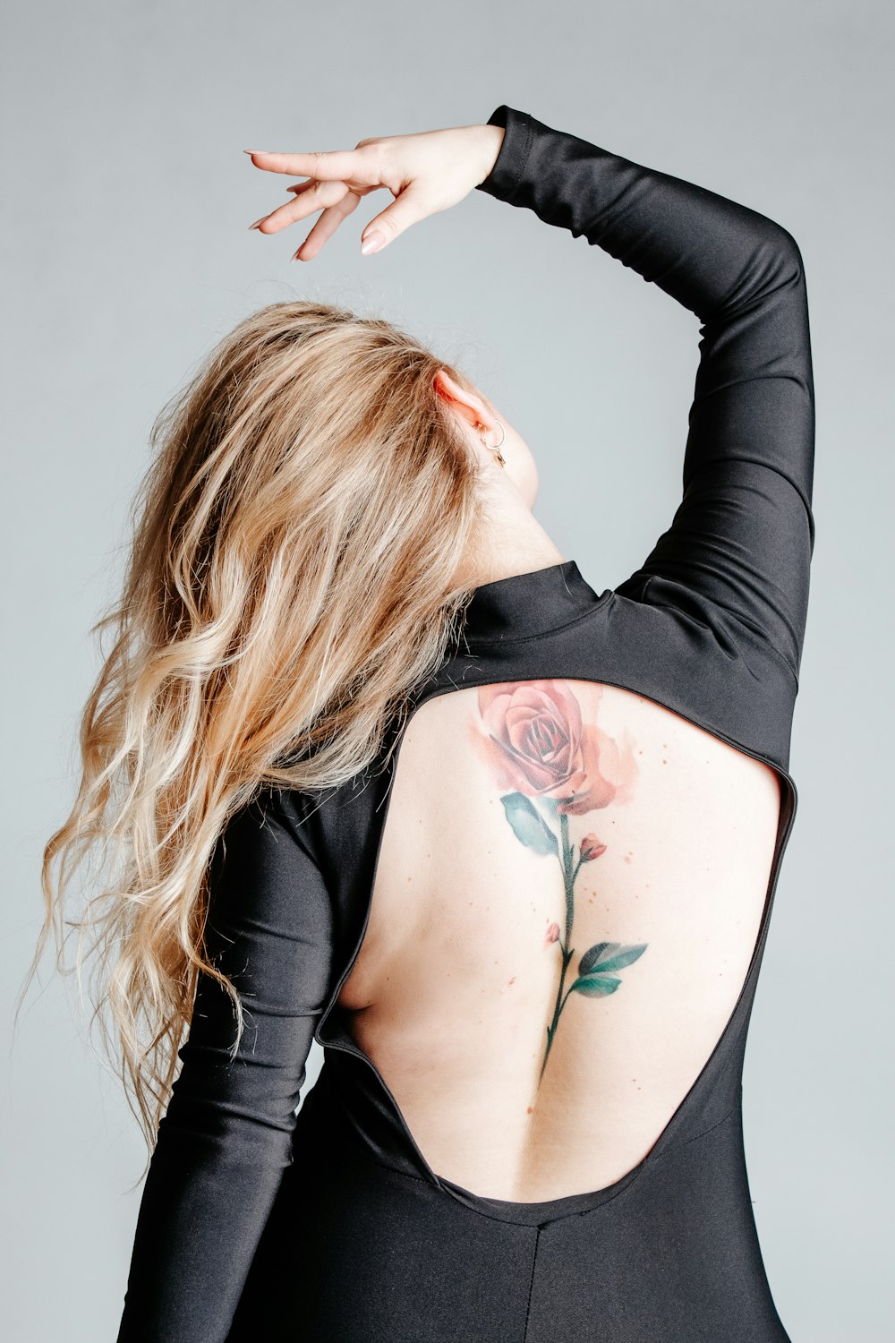 woman with red and green rose tattoo on her right arm