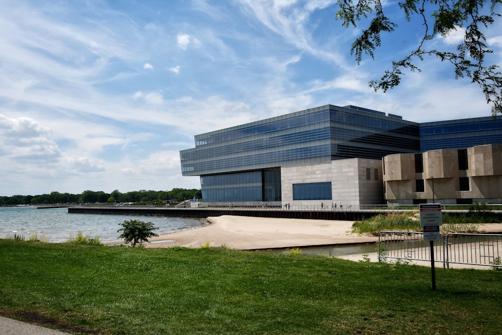 white concrete building near green grass field and body of water during daytime