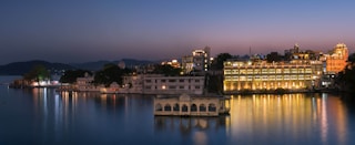 white concrete building near body of water during night time