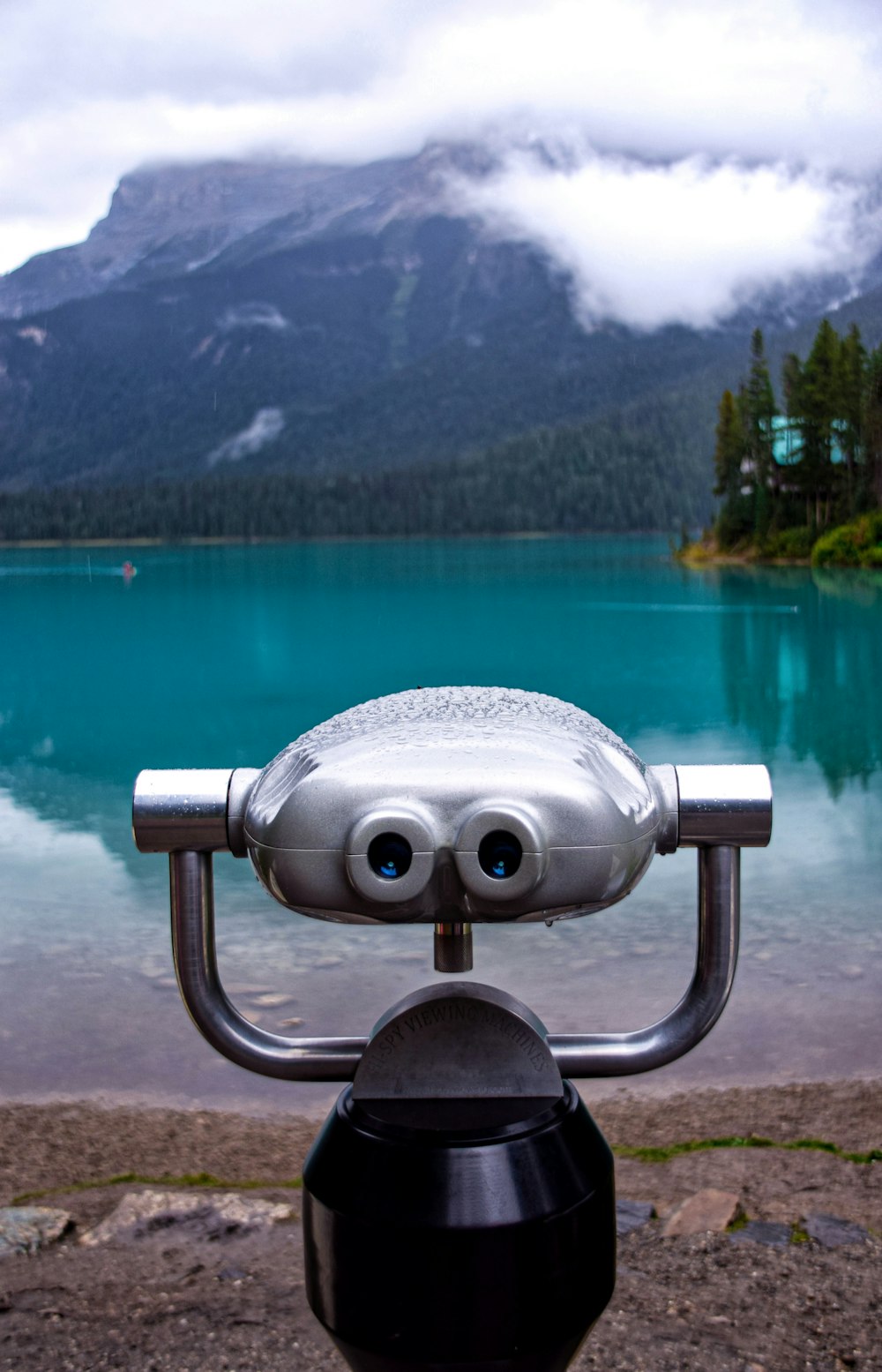 gray coin operated binoculars near lake and mountain during daytime