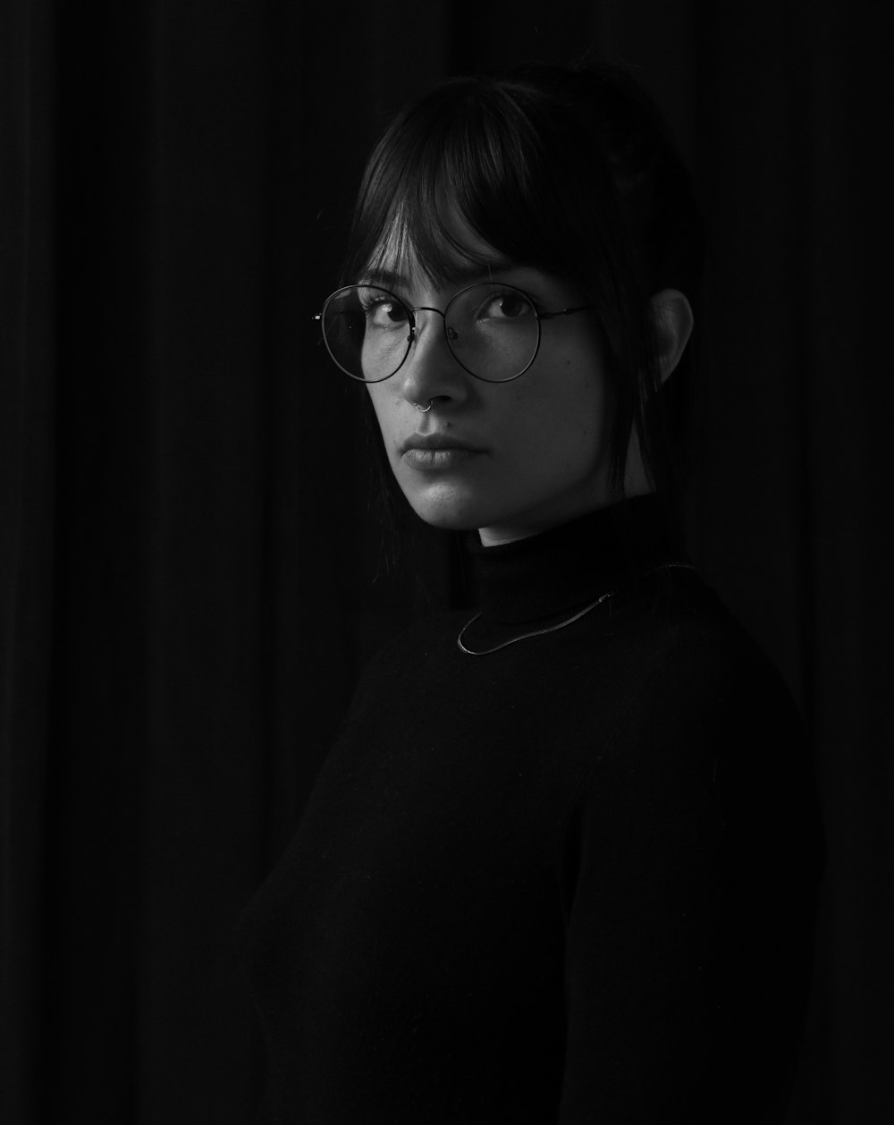 grayscale photo of woman wearing eyeglasses and turtle neck sweater