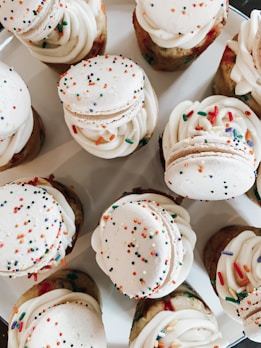A colorful assortment of mini cupcakes with swirled frosting and sprinkles.