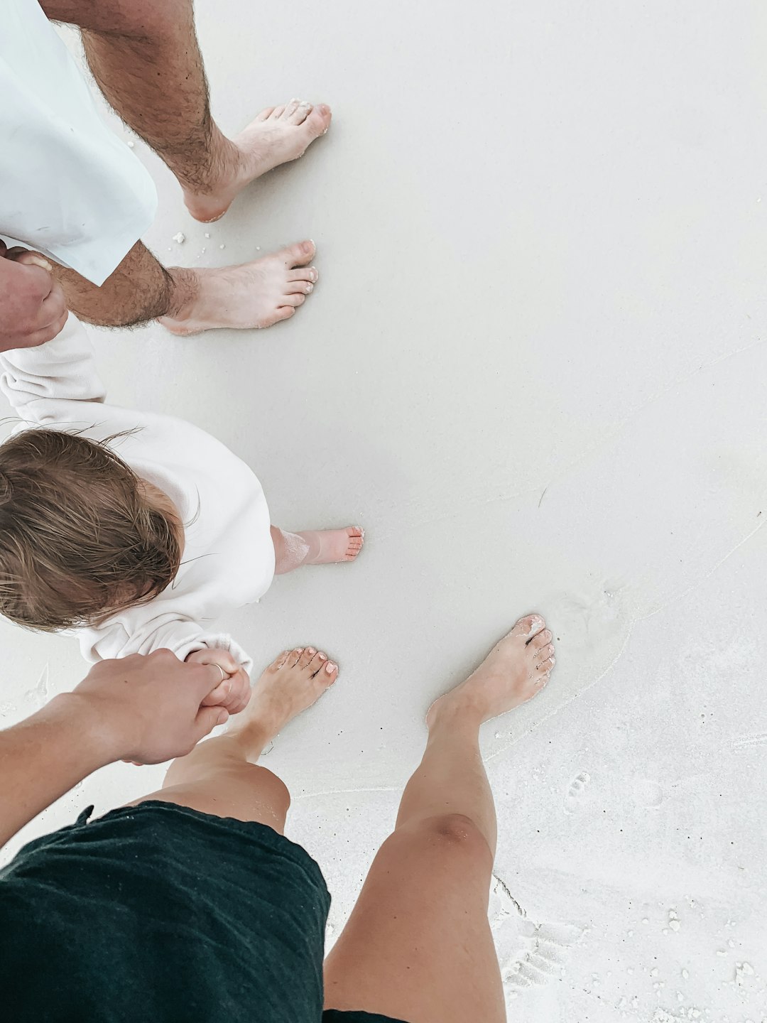 2 boys lying on white sand