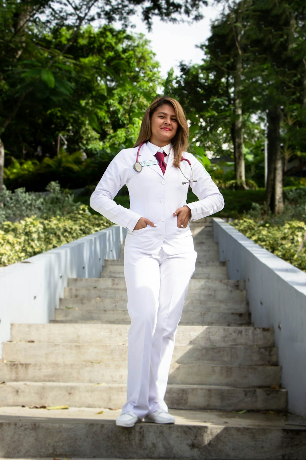 woman in white dress shirt and white pants standing on concrete bridge during daytime