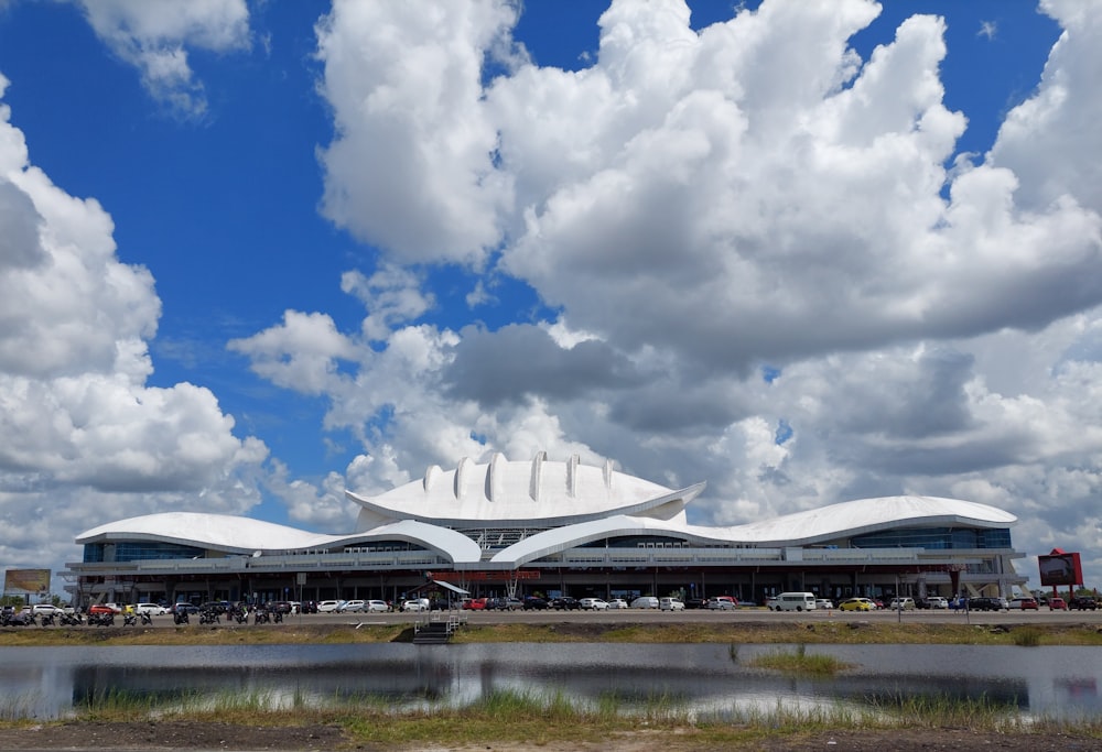 white building near body of water under blue and white cloudy sky during daytime