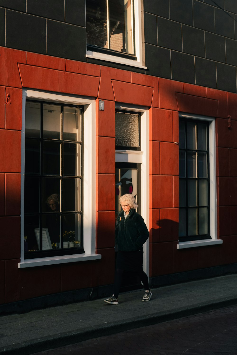 man in black jacket standing in front of brown concrete building during daytime