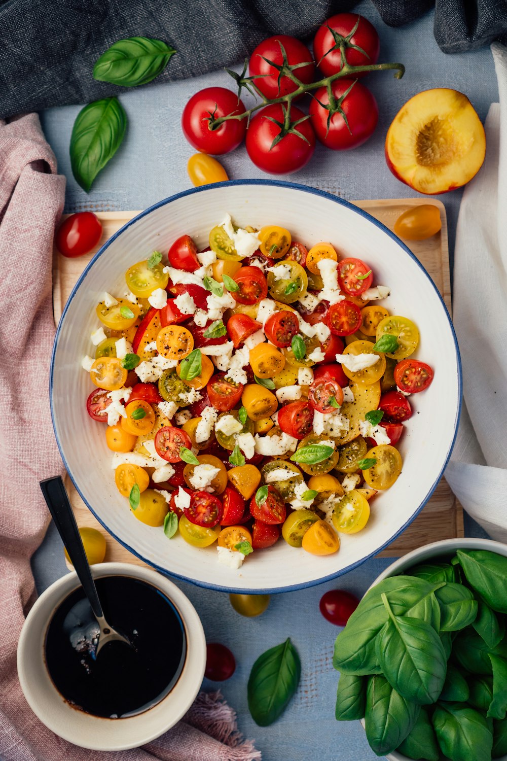 a white bowl filled with a salad next to a cup of coffee