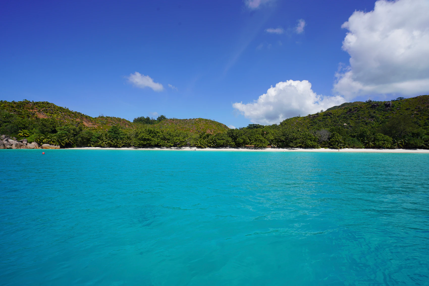 Clear turquoise water and a forested shore at Anse Lazio on Praslin