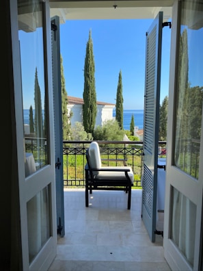 A sunlit modern apartment balcony overlooking the Mediterranean Sea in Cyprus.
