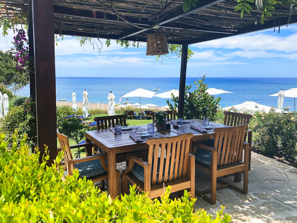 brown wooden table with chairs and table on beach during daytime