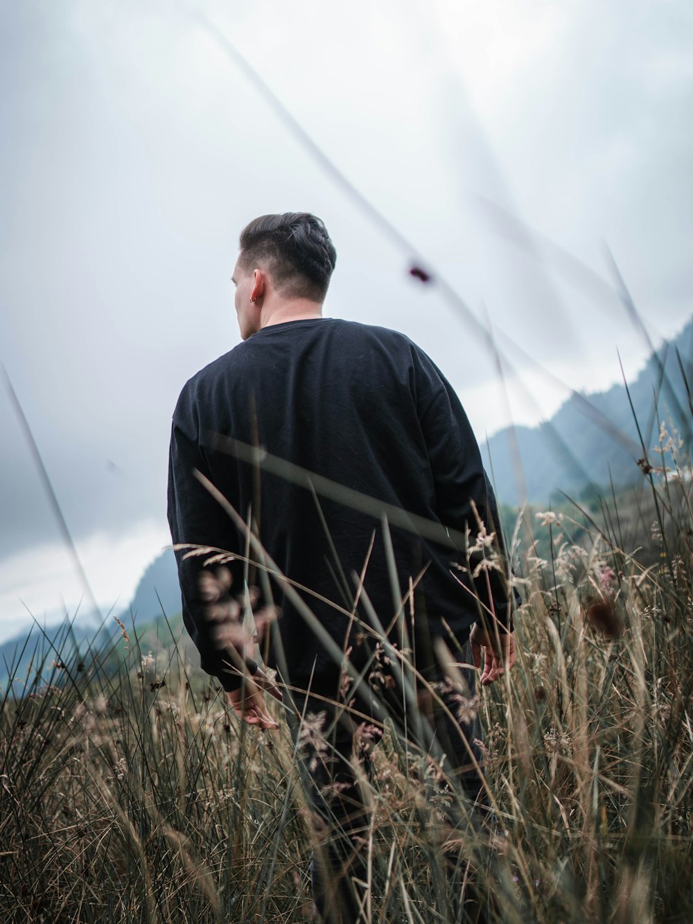 man in black jacket standing on green grass field during daytime