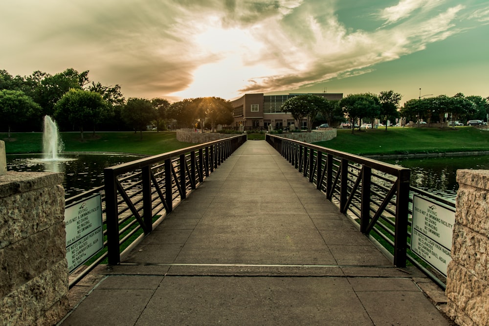 gray wooden bridge over river under gray clouds during daytime