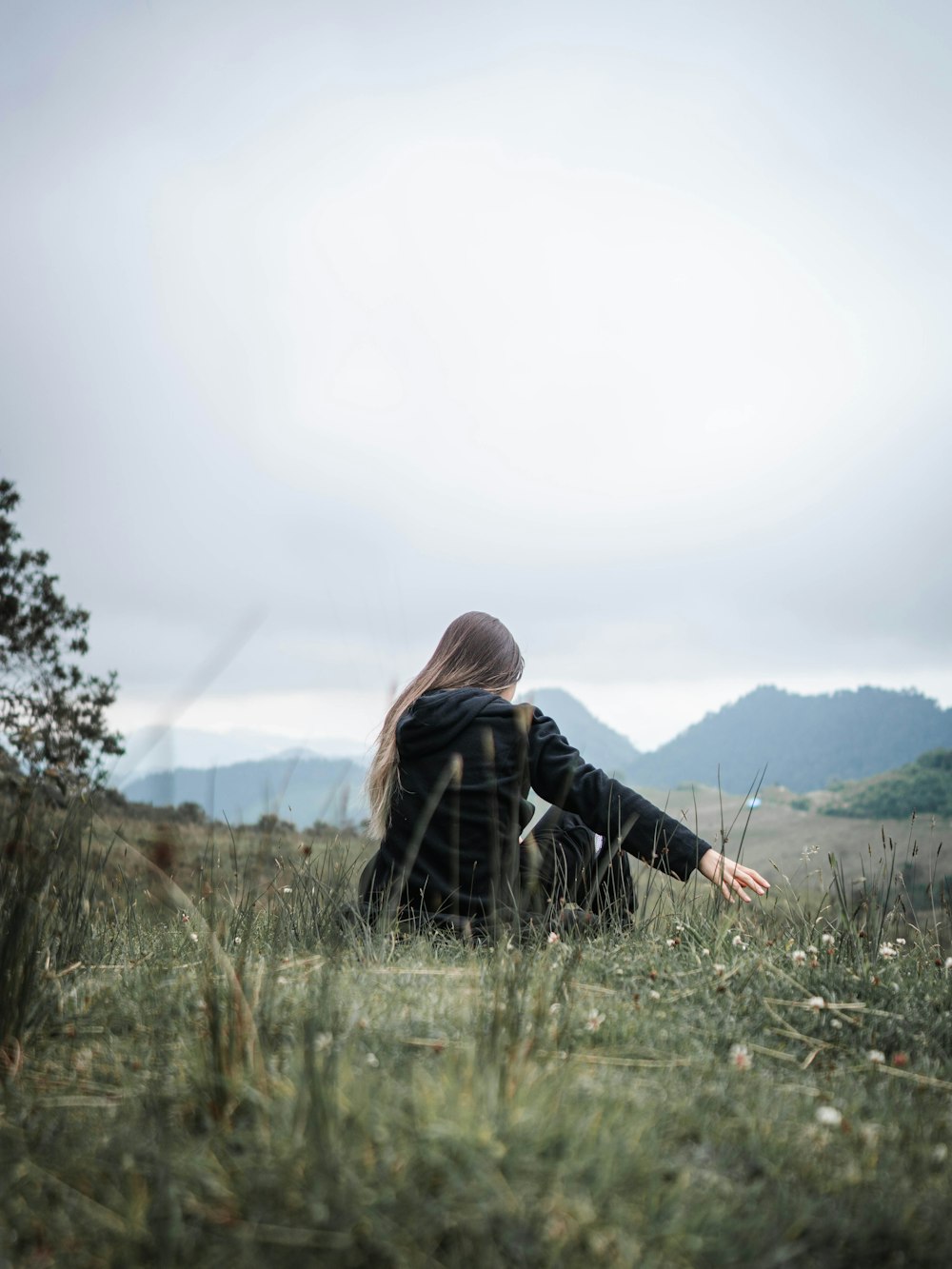 woman in black jacket standing on green grass field during daytime