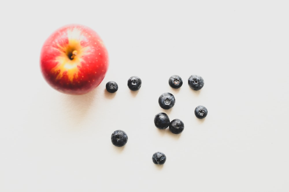 manzana roja junto a cuentas redondas negras