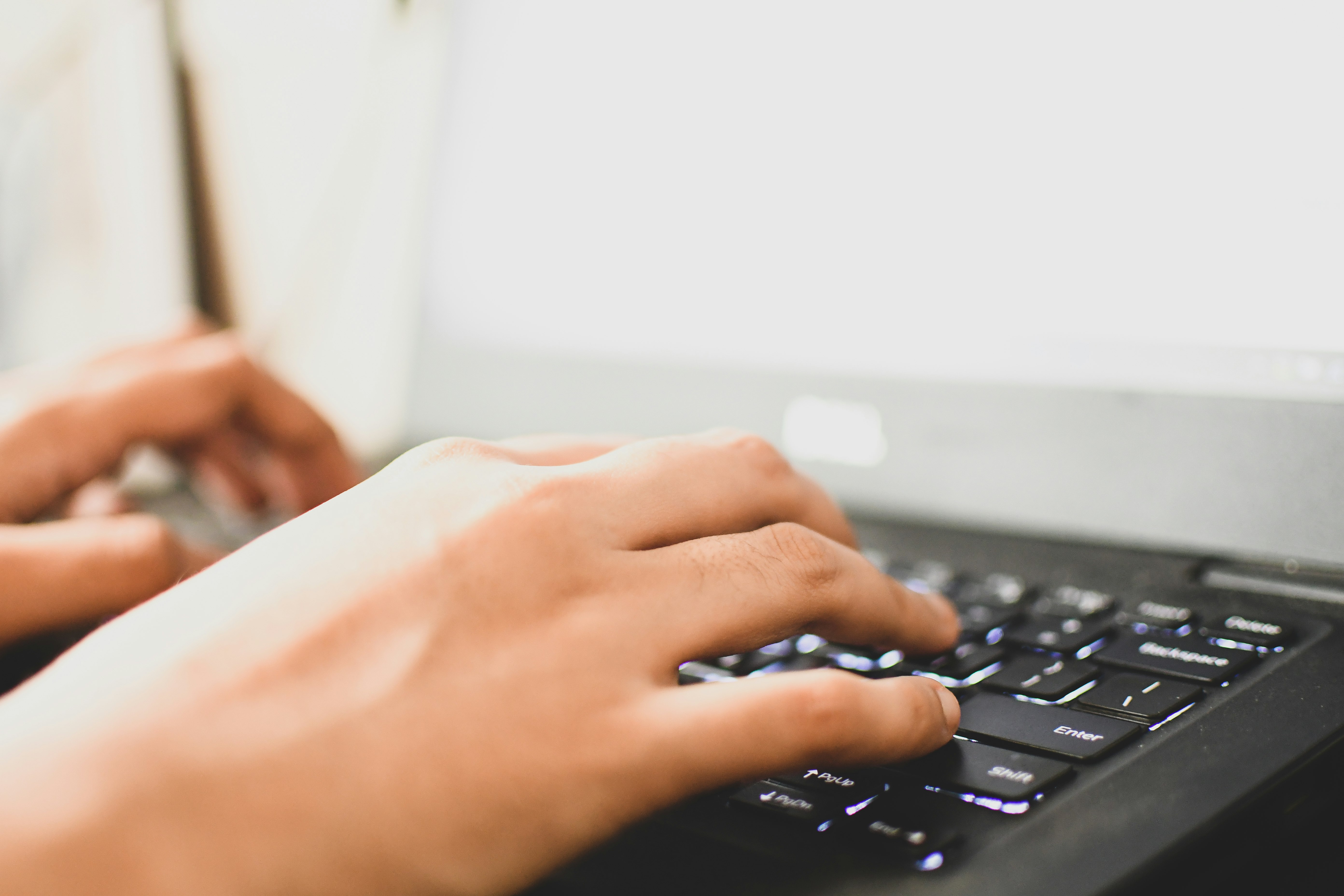 Closeup of a woman's hands typing on a laptop