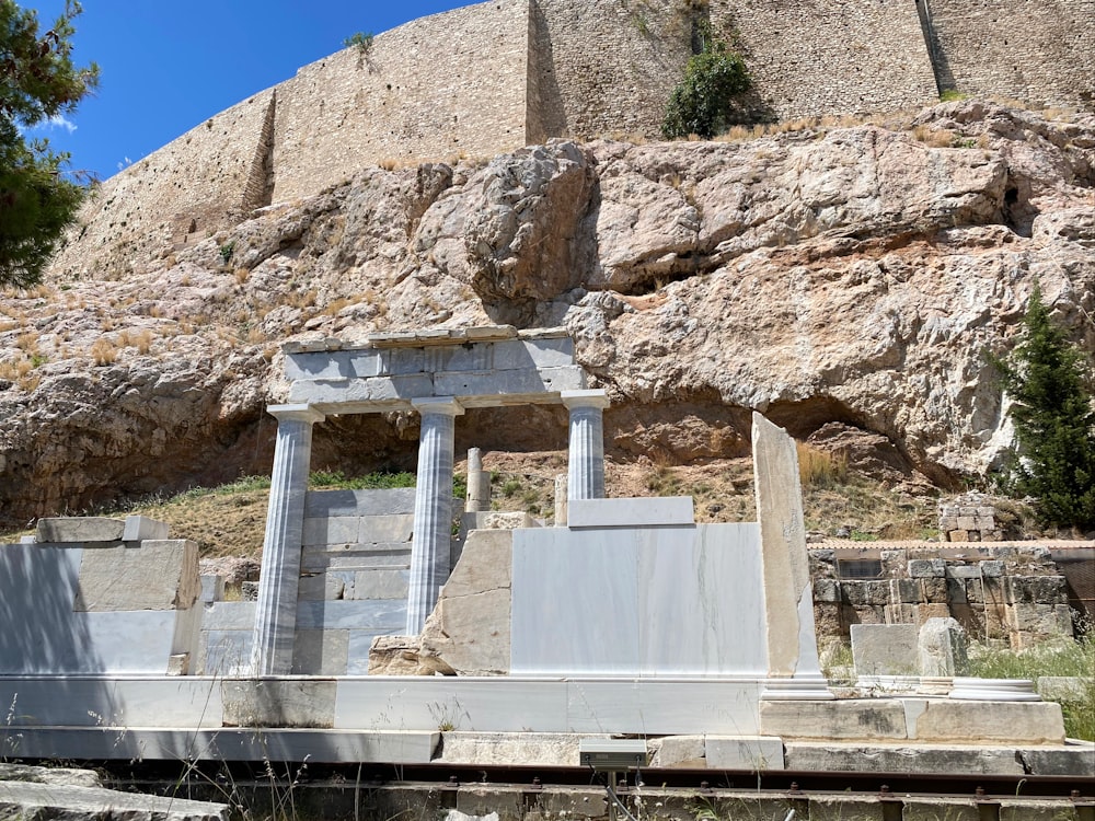 white concrete building near brown rock formation during daytime