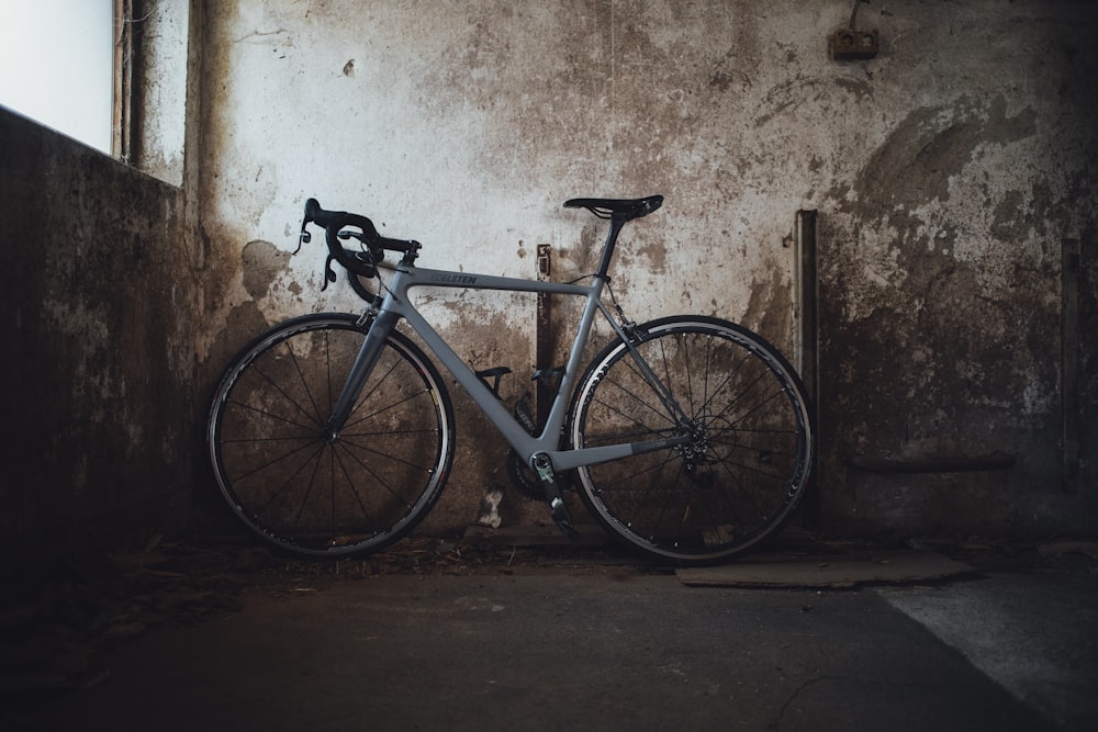 blue and white road bike leaning on wall