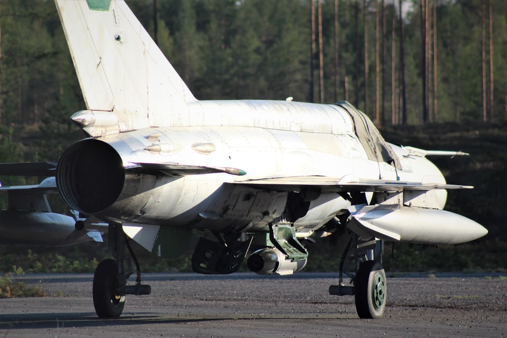 gray fighter plane on gray asphalt road during daytime