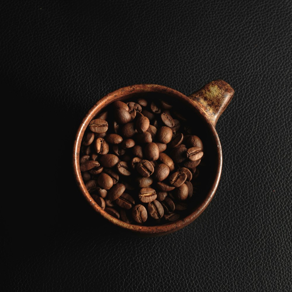 coffee beans in brown ceramic mug