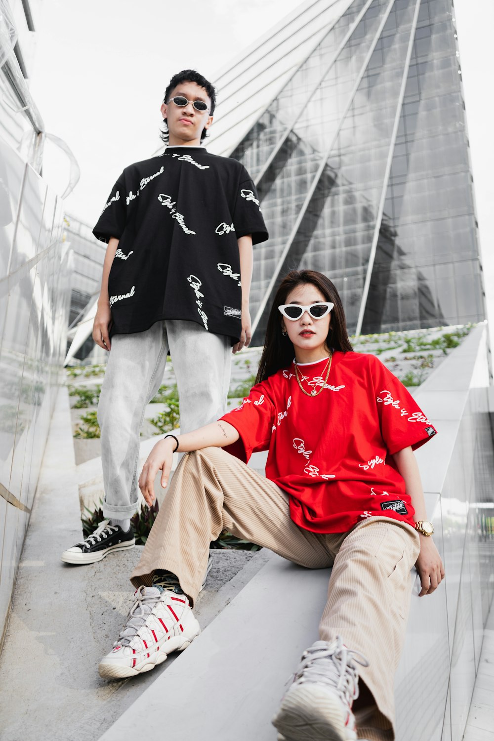 man in red and white polo shirt and brown pants sitting on white concrete bench