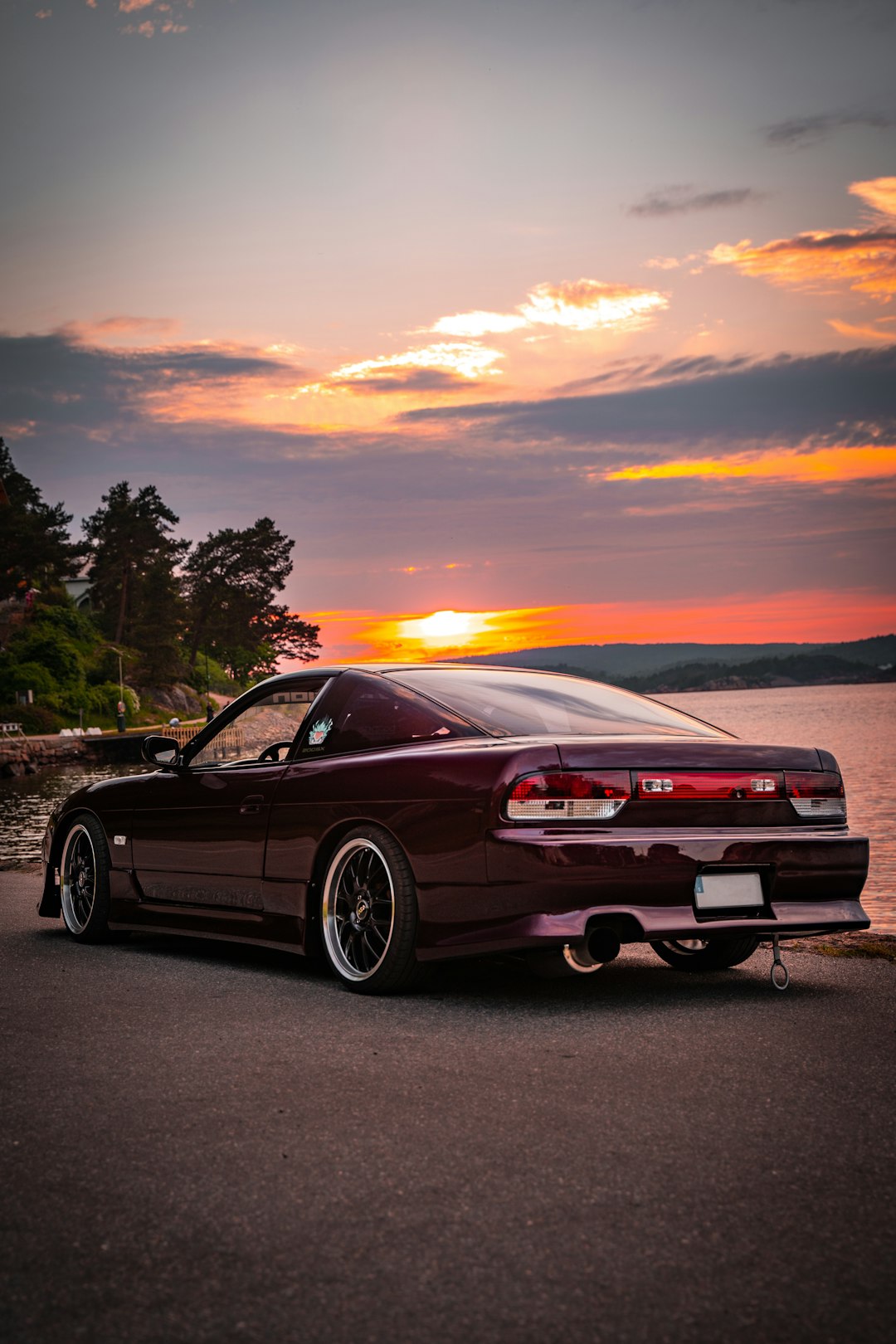 red chevrolet camaro on road during sunset