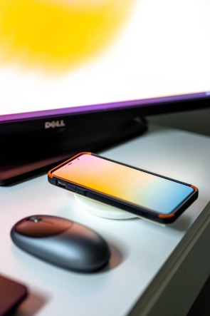 A wireless charger glowing softly beneath a modern elite phone, set against a lively gradient backdrop.