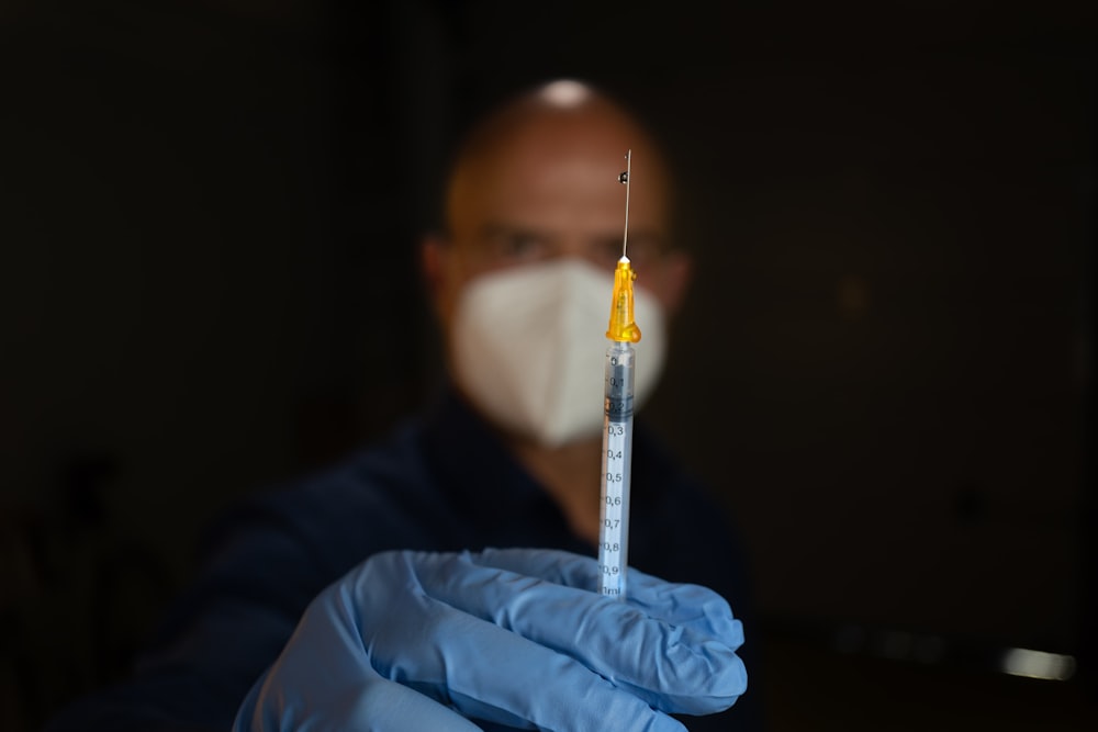 white and clear syringe on blue textile