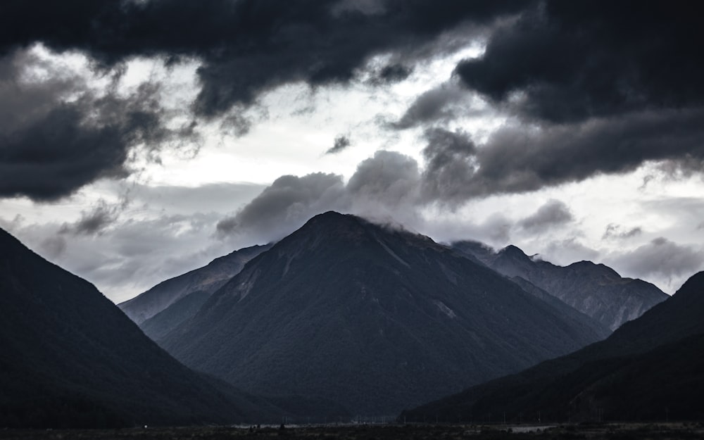 green and black mountain under white clouds