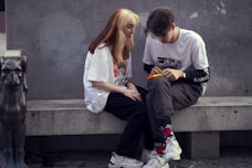 man in white crew neck t-shirt sitting beside woman in white crew neck t-shirt