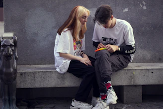 man in white crew neck t-shirt sitting beside woman in white crew neck t-shirt