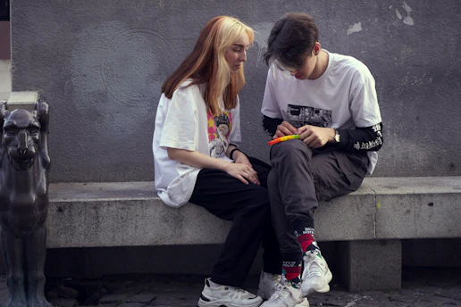 man in white crew neck t-shirt sitting beside woman in white crew neck t-shirt