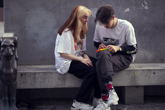 man in white crew neck t-shirt sitting beside woman in white crew neck t-shirt