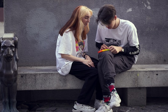 man in white crew neck t-shirt sitting beside woman in white crew neck t-shirt