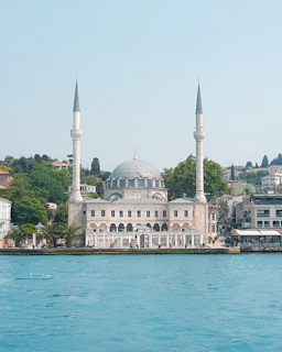 white and brown concrete building near body of water during daytime