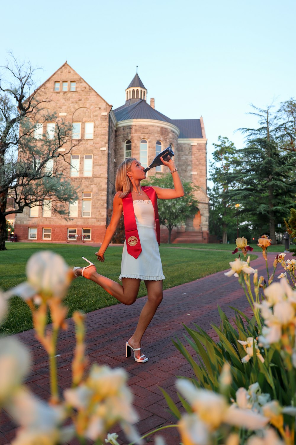 woman in red and white dress standing on green grass field during daytime