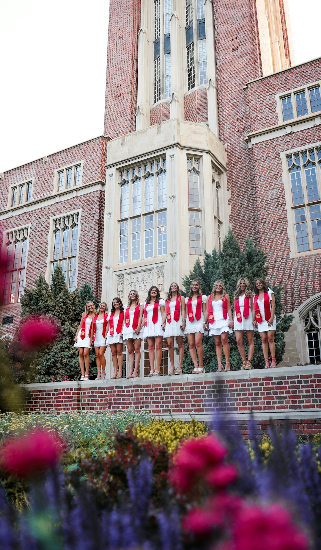 group of people in red and white uniform standing in front of brown concrete building during