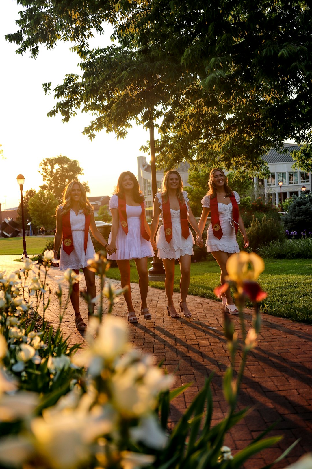 group of women standing on brown brick pathway during daytime