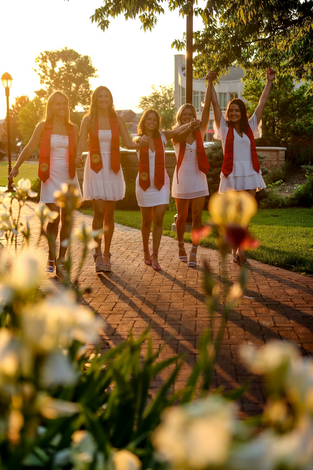 3 women in white dress standing on brown brick pathway during daytime