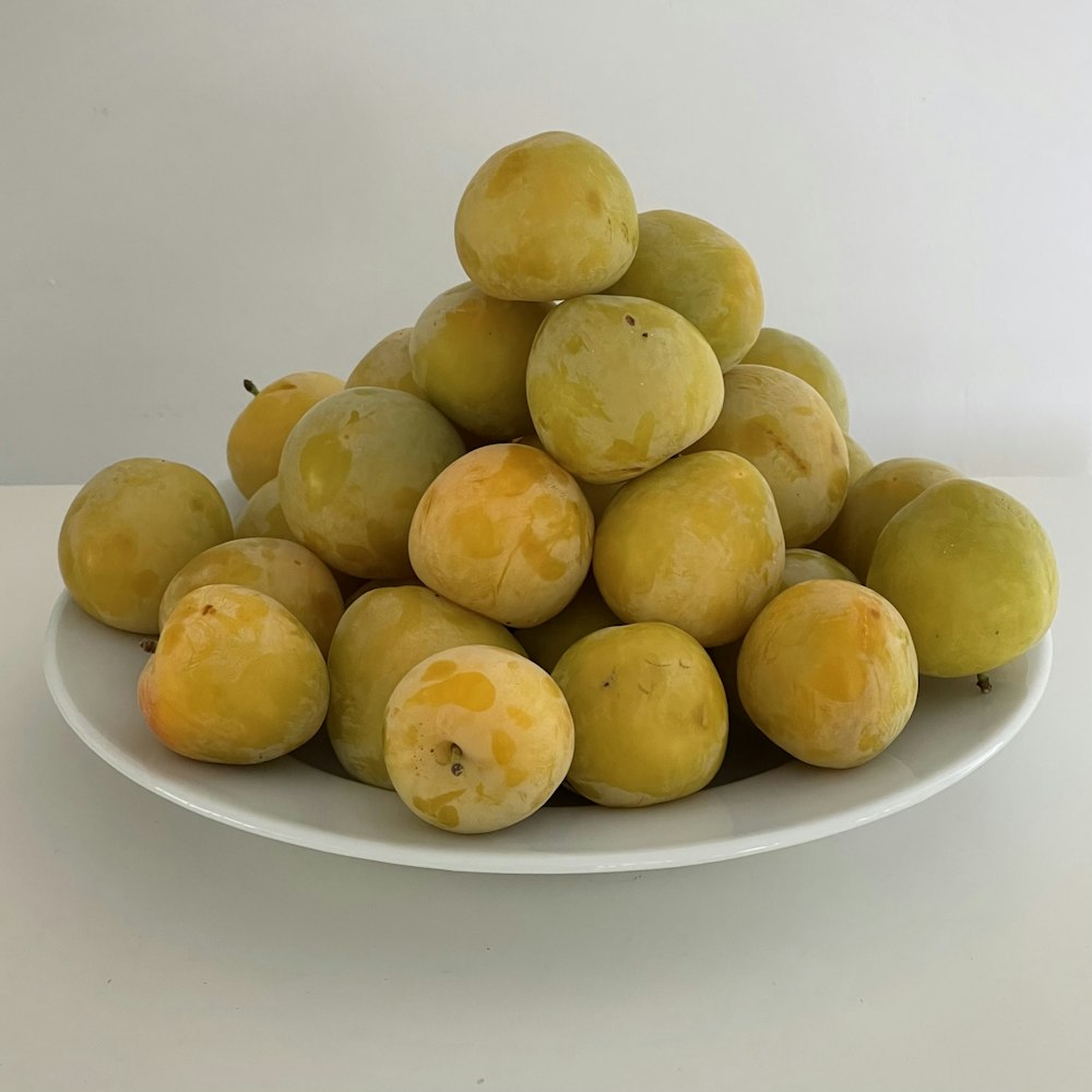 yellow round fruits on white ceramic plate