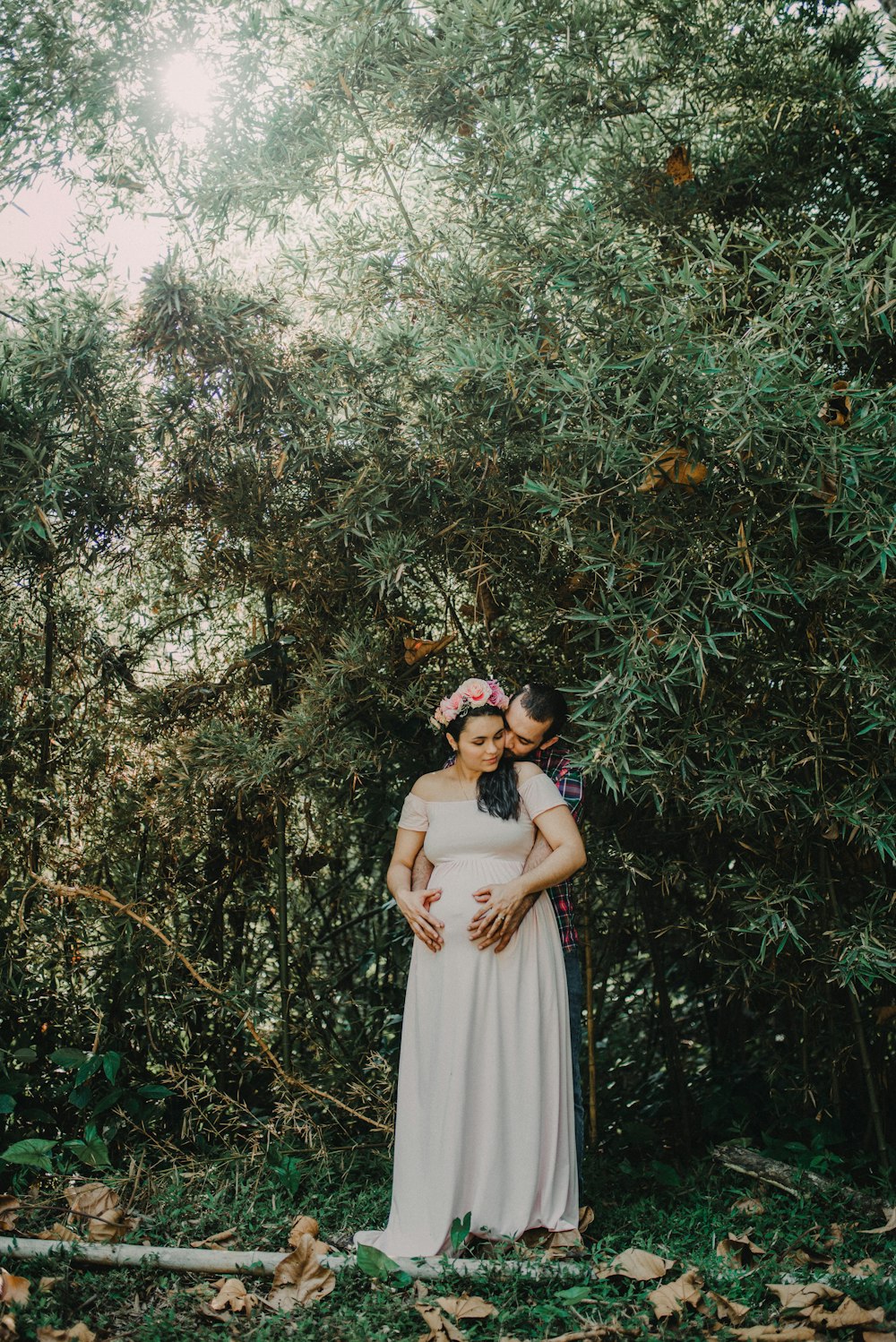 woman in white dress standing under green tree during daytime