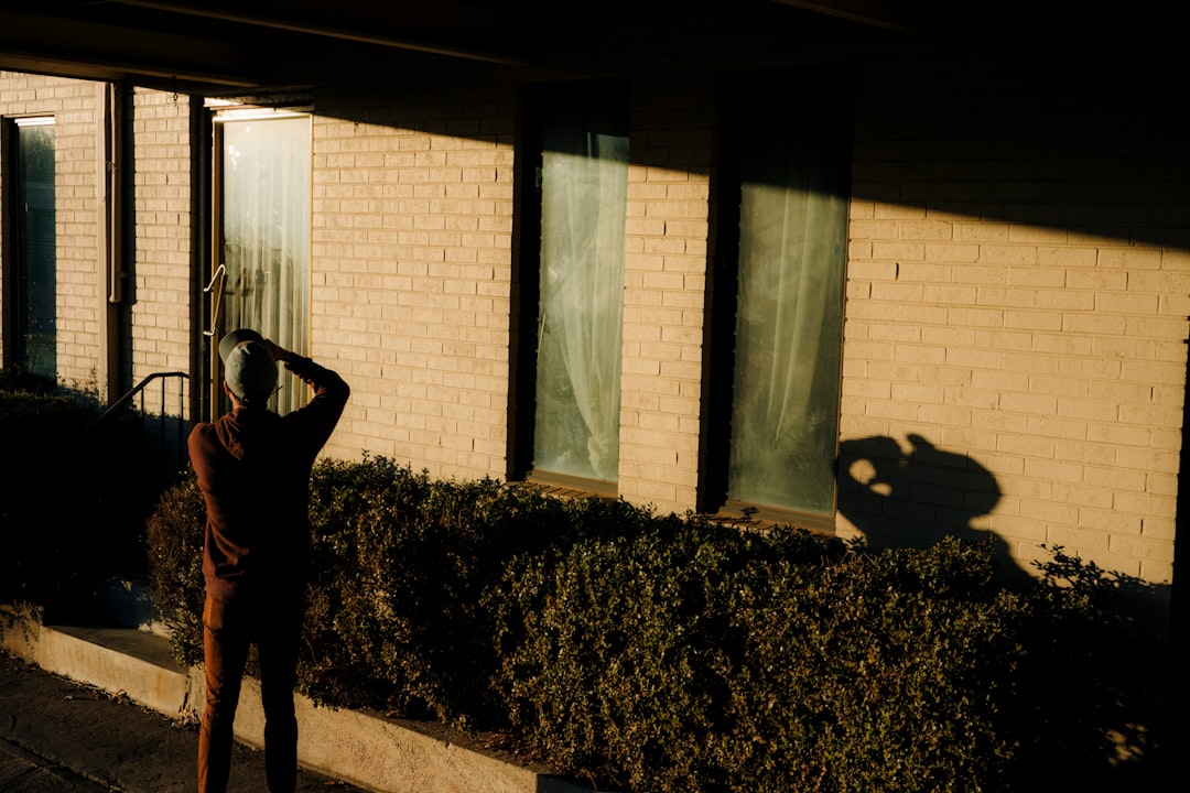 person in black jacket standing near green plant during daytime