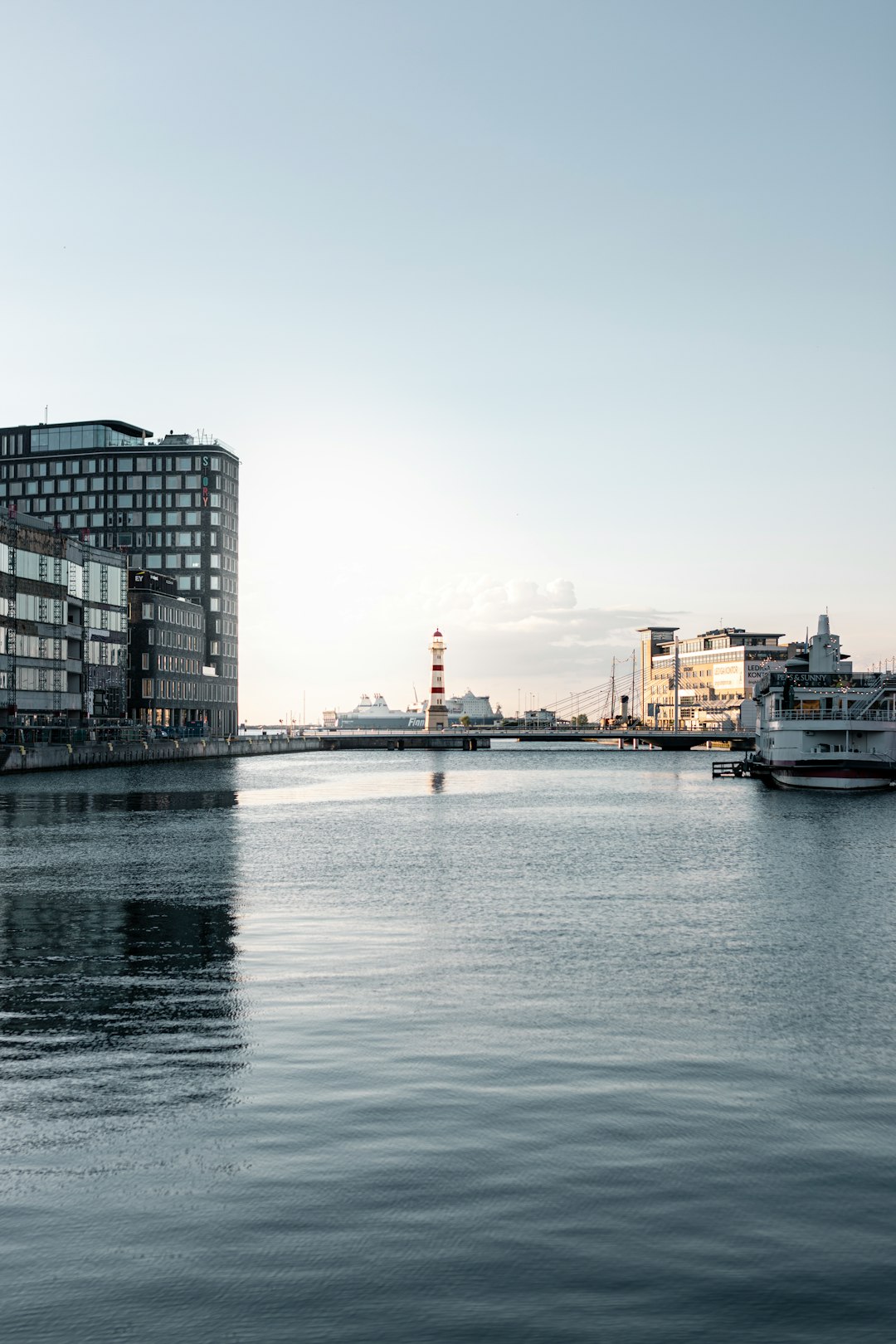 white and black boat on water near city buildings during daytime