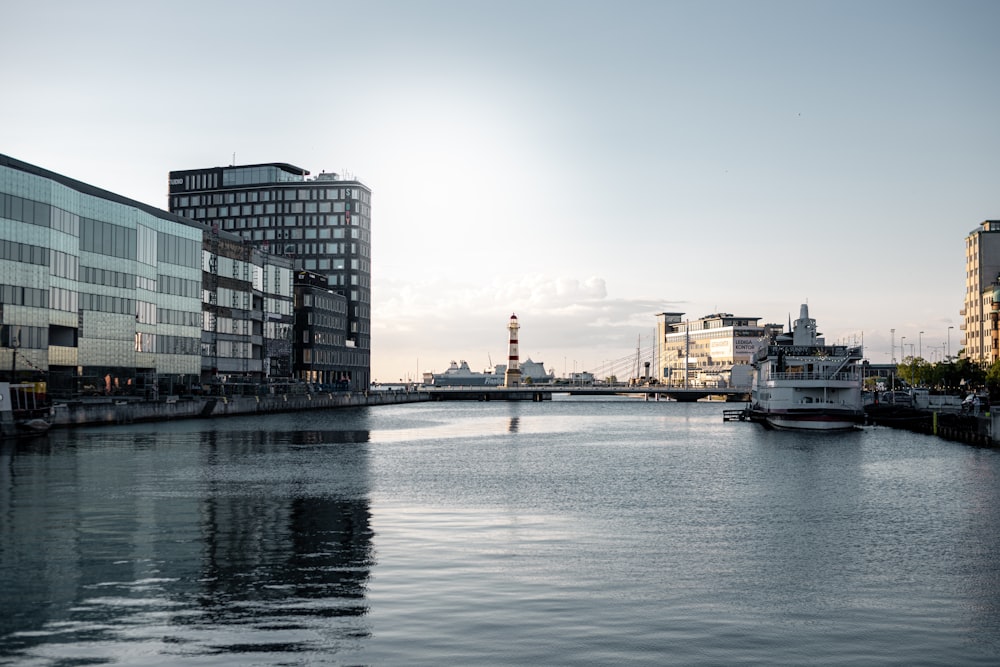 weißes Boot tagsüber auf dem Wasser in der Nähe von Stadtgebäuden