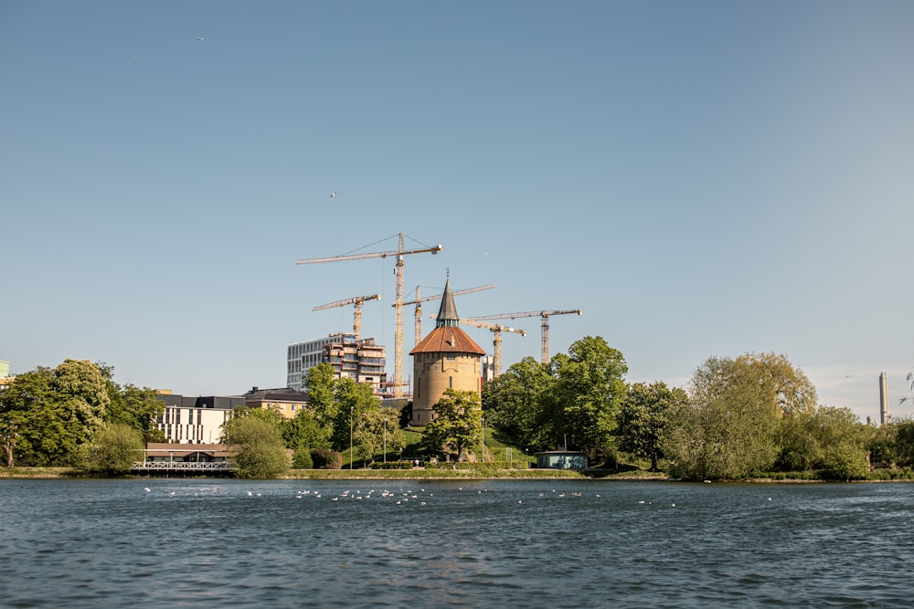 Bâtiment en béton brun et blanc près d’un plan d’eau pendant la journée