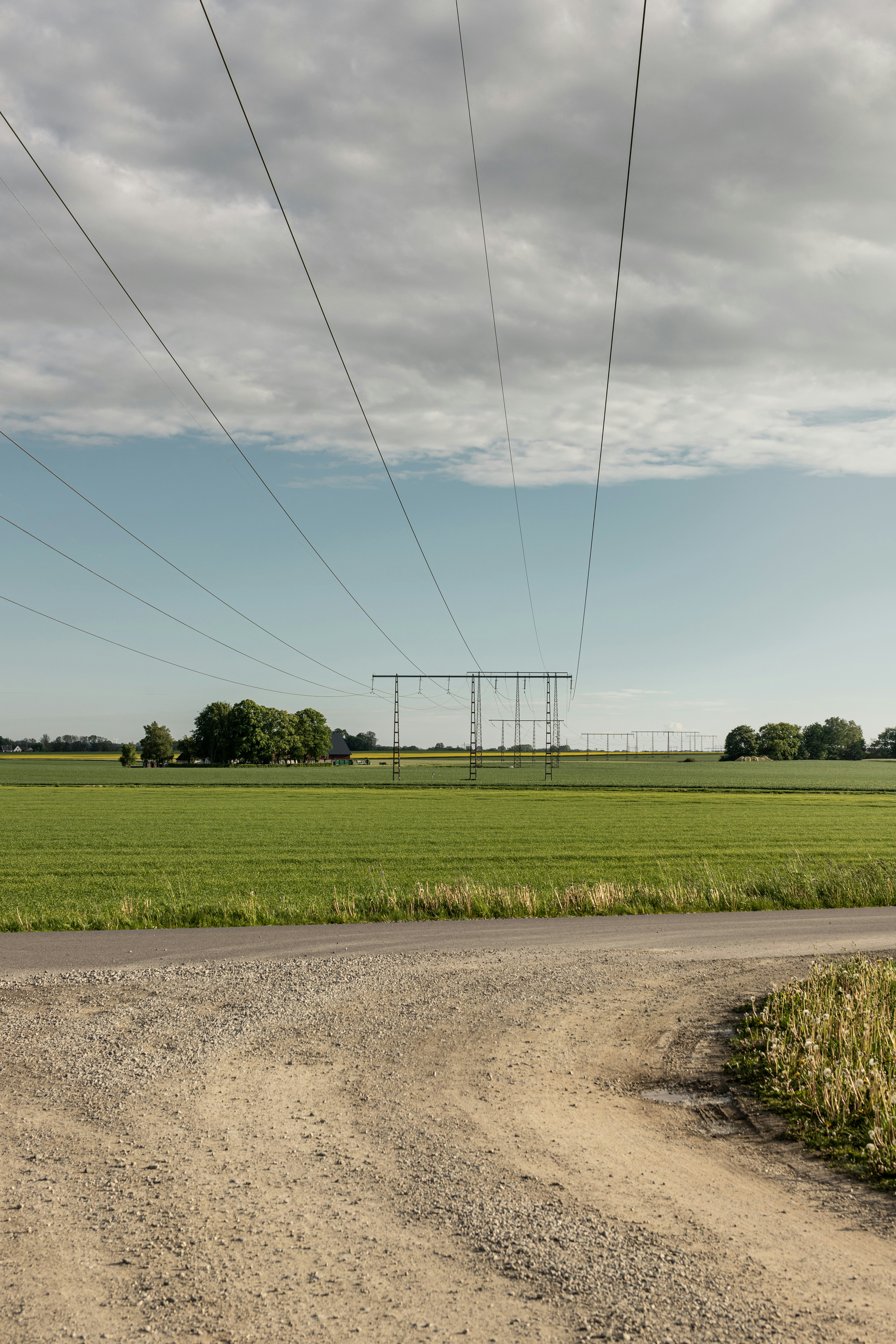 Grünes Grasfeld unter weißen Wolken und blauem Himmel tagsüber