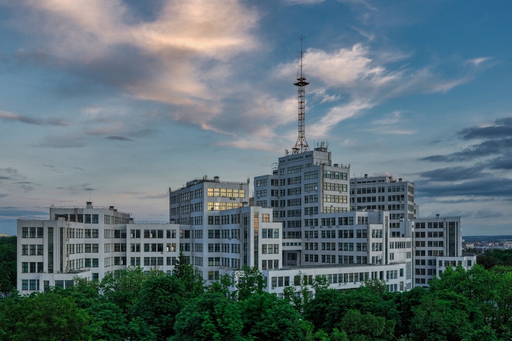 white and brown concrete building near green trees under cloudy sky during daytime