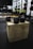 A gym setting with two black hexagonal dumbbells placed on a wooden plyometric box. In the background, there are various pieces of workout equipment including weight racks and bars. The scene appears focused and organized.